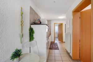 a kitchen with a white refrigerator and a table and chairs at Ferienwohnung am Hof in Zwiefalten