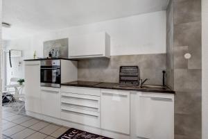 a kitchen with white cabinets and a stove at Ferienwohnung am Hof in Zwiefalten