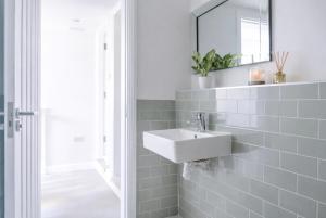 a white bathroom with a sink and a mirror at Duplex Apartment - Central Harrogate Apartment in Harrogate