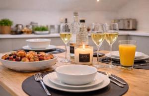 a table with glasses of wine and a plate of food at Duplex Apartment - Central Harrogate Apartment in Harrogate
