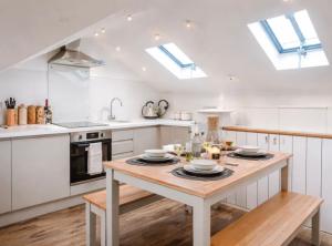 a kitchen with white cabinets and a wooden table at Duplex Apartment - Central Harrogate Apartment in Harrogate