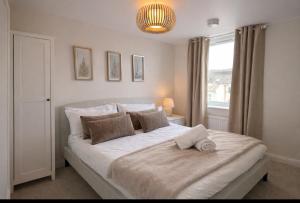 a bedroom with a large white bed with a window at Duplex Apartment - Central Harrogate Apartment in Harrogate +2 photos