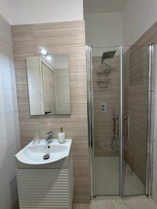 a bathroom with a sink and a shower at Trapani Urban Nest in Trapani