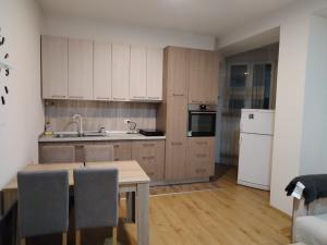 a kitchen with a table and a white refrigerator at Stan na dan in Svilajnac
