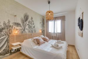 a bedroom with a large bed with towels on it at Villa Mézoise in Mèze