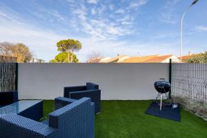 a patio with blue chairs on the grass at Villa Mézoise in Mèze