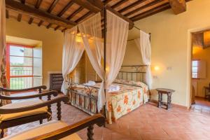 a bedroom with a canopy bed and two chairs at Tenuta Di Monaciano in Ponte A Bozzone +81 photos