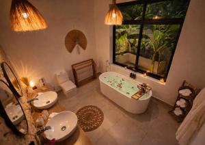 a bathroom with a tub and two sinks and a window at Bahari Mirror Villas in Jambiani +30 photos