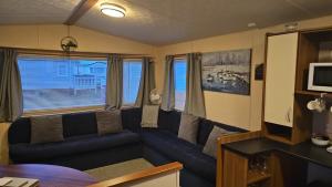 a living room with a blue couch in a room at Seagulls Sunrise in Seasalter