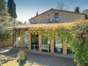 a house with a pergola and two benches at San Giovanni Residence in Peccioli