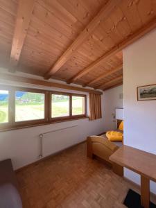 a living room with a couch and two windows at Residence Zirmer Wohnung Luft in Castelrotto