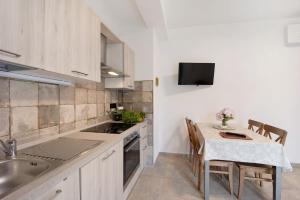 a kitchen with a sink and a table with a tablecloth at Antichi Ricordi - La Stalla in Marina di Andora