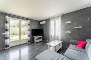 a living room with a couch and a tv at Chalet en Provence in Sorgues
