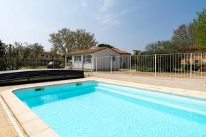 a swimming pool in front of a fence at Chalet en Provence in Sorgues