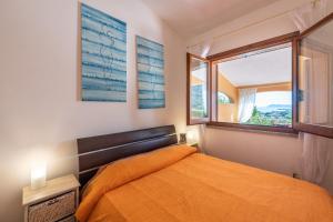 a bedroom with an orange bed and a window at Domixedda in Costa Rei