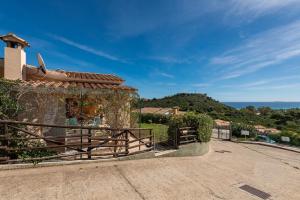 a house with a gate and a view of the ocean at Domixedda in Costa Rei