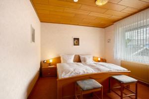 a bedroom with a bed with two chairs in it at Haus Zur Laterne in Willingen