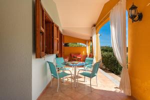 a dining room with a table and chairs on a patio at Domixedda in Costa Rei