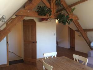 a dining room with a wooden table and chairs at Le Chêne Doux in Glandon