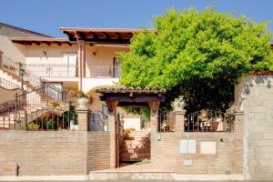 a brick house with a staircase and a tree at Casa Rosa in Fluminimaggiore