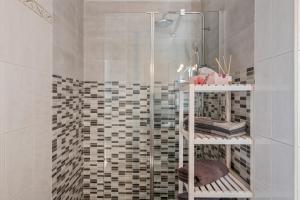 a bathroom with a shower with black and white tiles at Casa Barriguita 2 in Playa Blanca +12 photos