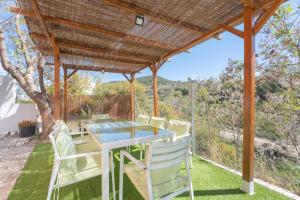 a table and chairs under a wooden pergola at Castellana in Bicorp