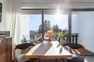 a dining room table with chairs and a large window at Ferienwohnung Seebruck in Seebruck