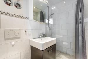 a white bathroom with a sink and a shower at Ferienwohnung Seebruck in Seebruck