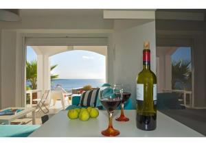 a bottle of wine sitting on a table with a glass at Kaladi Rock Ammos in Avlemonas