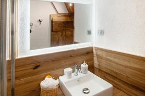 a bathroom with a white sink and a mirror at Sweet Somma Mountain Lodge 1 in San Guglielmo