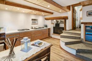 a kitchen with wooden cabinets and a fireplace at Sweet Somma Mountain Lodge 1 in San Guglielmo