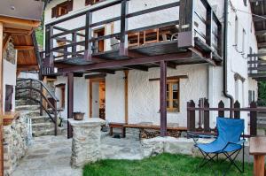 a house with a balcony and a blue chair at Sweet Somma Mountain Lodge 1 in San Guglielmo
