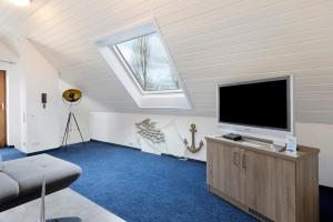a living room with a flat screen tv and a window at Untersee Appartements in Moos