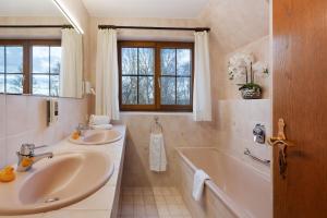 a bathroom with two sinks and a tub and a window at Untersee Appartements in Moos +22 photos