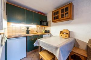 a small kitchen with green cabinets and a table at Appartement Résidence Ours Blanc in Les Houches +10 photos