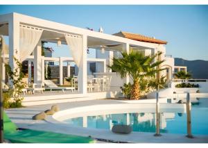 a white house with a swimming pool in front of it at Kaladi Rock Ammos in Avlemonas