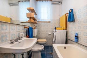 a bathroom with a sink and a toilet and a tub at Casa nel Borgo Iris in Breguzzo +17 photos