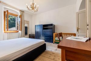 a bedroom with a desk and a bed and a desk sidx sidx sidx at Casa nel Borgo Iris in Breguzzo