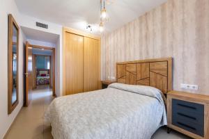 a bedroom with a bed and a wooden headboard at Sofie apartamento turístico in Roquetas de Mar +23 photos