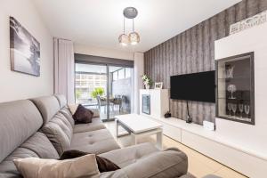 a living room with a couch and a tv at Sofie apartamento turístico in Roquetas de Mar