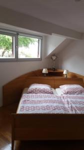 a bedroom with two beds and two windows at Haus Moselschleife in Bremm