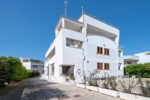 a white building with an arch on a street at Case Vacanze Otranto in Otranto