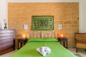 a bedroom with a green bed with towels on it at Domus mea salento Arazzo Verde in Ugento +21 photos