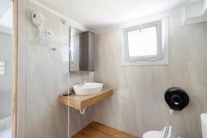 a white bathroom with a sink and a window at Iguana studio 17 in Preveza +23 photos