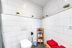 ein Badezimmer mit weiß gefliesten Wänden und einer Toilette in der Unterkunft Fewo Al Backstuff in Hambuch