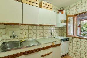 a kitchen with white cabinets and a sink and a window at Villa Alejo in Valsequillo