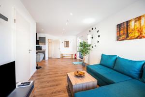ein Wohnzimmer mit einem blauen Sofa und einem Tisch in der Unterkunft Fewo Al Backstuff in Hambuch