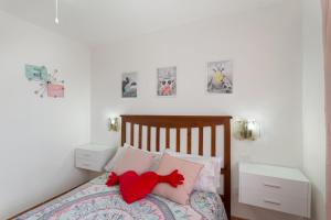 a bedroom with a bed with a red stuffed animal on it at Villa Alejo in Valsequillo