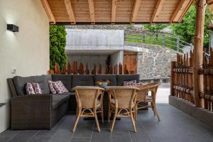 a patio with a couch and tables and chairs at Weirerhof Lebm Gspiarn in Barbiano