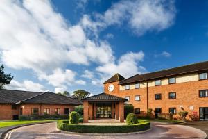 a large brick building with a clock on it at Delta Hotels by Marriott Milton Keynes in Milton Keynes